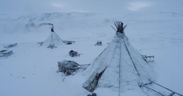 Drone capturant les yourtes en gros plan dans la soirée au milieu de l'Arctique, beaucoup de traîneau à l'extérieur des yourtes . — Video