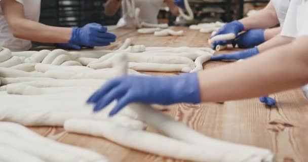 En una gran industria panadera dos panaderos con guantes azules preparan la masa, amasando la masa para preparar el pan. 4k — Vídeos de Stock