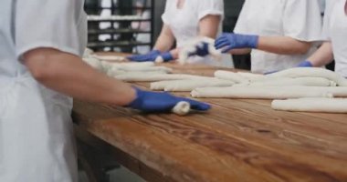 Bir fırın raflarından video detayları alarak fırın yoğurma hamur üzerinde çalışan insanlar organik ekmek pişirmeye hazır olsun