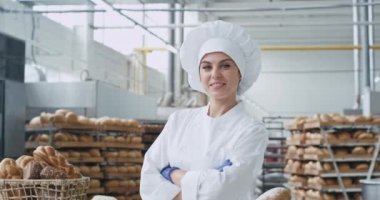Endüstriyel bir mutfakta kamera karizmatik fırıncı kadın önünde büyük gülümseyen ve kamera arka plan büyük endüstriyel fırın makinesi ne kadar başıboş görünümlü