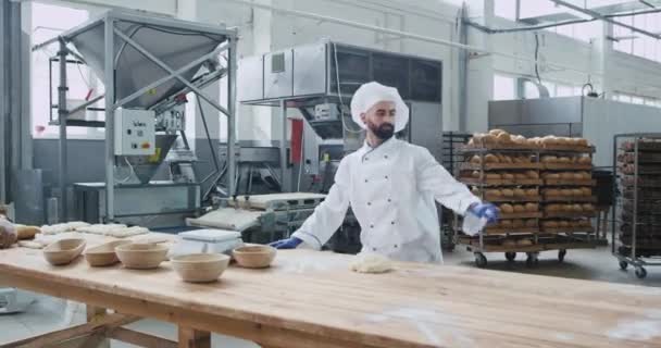 跳舞兴奋的男子面包师在厨房面包店在他的工作桌享受工作时间，同时准备面团成型件 — 图库视频影像