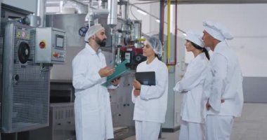 Adam mühendis ve onun yardım gıda sanayi fabrikasında bir toplantı var o endüstriyel makine hakkında talimatlar ve güvenlik notları açıklar