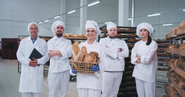 Dobrze wyglądający główny zespół w przemyśle piekarniczym Bakers inżynier patrząc prosto do aparatu i uśmiechając się całkiem w Wielkiej fabryce piekarni — Wideo stockowe