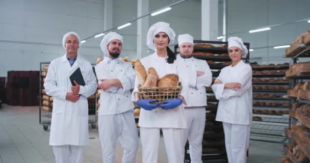 Bakkerij fabriek hoofd team van bakkers en ingenieur in een geweldige sfeer op zoek rechtstreeks naar de camera en glimlach — Stockvideo