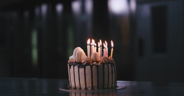 Retrato de primer plano de un pastel de chocolate con velas de cumpleaños dentro en una cocina de panadería comercial — Vídeo de stock