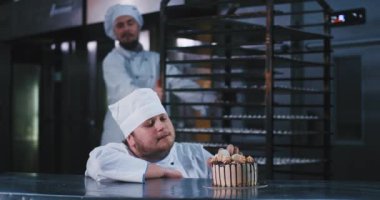 Bir şef kıyafetleri giyen ağır görünümlü fırıncı adam bu dayanılmaz pasta ve arkasında büyük bir tepsi iterek sakallı bir husky adam alır , bu lezzetli pasta ve yaprakları tatmak için katılır