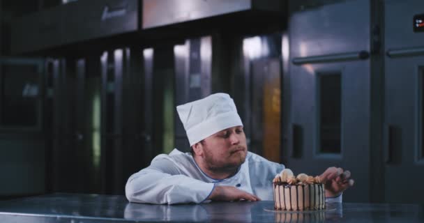 Este hombre de aspecto grueso con un rastrojo corto come este pastel de aspecto delicado en admiración por el delicioso sabor — Vídeos de Stock