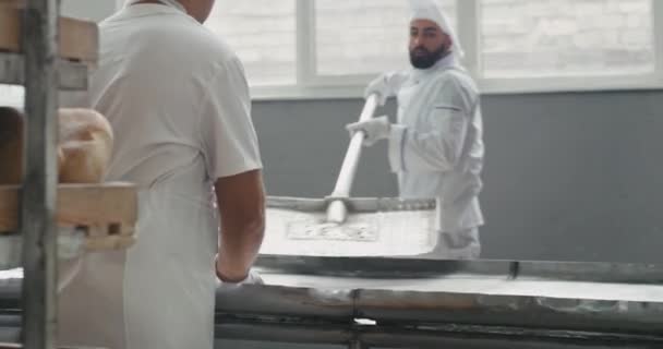 Celodenní pracovní proces vyložení chleba z trouby na speciálních policích v továrně na pekárnu — Stock video