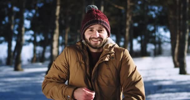 Молодой человек перед камерой очень харизматичный наслаждаясь временем на природе на снежном лесу усилитель большое чувство счастья . — стоковое видео