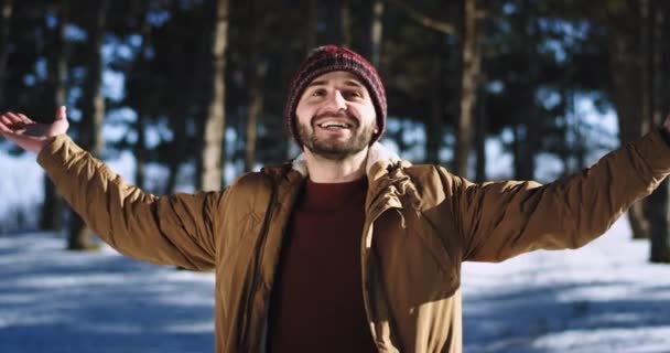 Carismatico con un grande uomo sorriso che si gode il tempo nella foresta nel periodo invernale prende un po 'd'aria fresca e si sente bene davanti alla telecamera — Video Stock