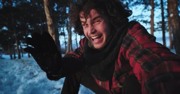 カメラの前で自分をキャプチャ雪の森の上の格好良い観光客は、彼が一人で旅行しながら時間を楽しんで非常に熱狂的なビデオを作ります — ストック動画