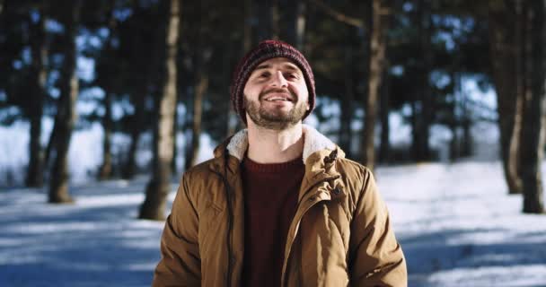 Guy take some fresh air in front of the camera in the forest winter time he smile large and feeling excited — Stock Video