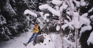 Adam turist tek başına karlı ormanın ortasında seyahat o zaman zevk etrafında tüm güzelliği hayran ve sıcak almak için bir mola için durdu biraz sıcak çay içecekler