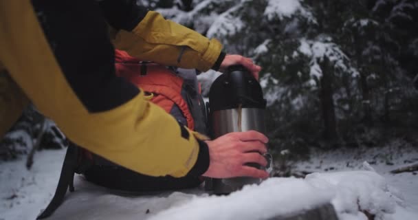 Rincian closeup seorang turis muda bepergian sendirian ia menuangkan dari termos beberapa minuman panas dalam cangkir besi dan mulai minum sangat bersemangat ia menikmati perjalanannya — Stok Video