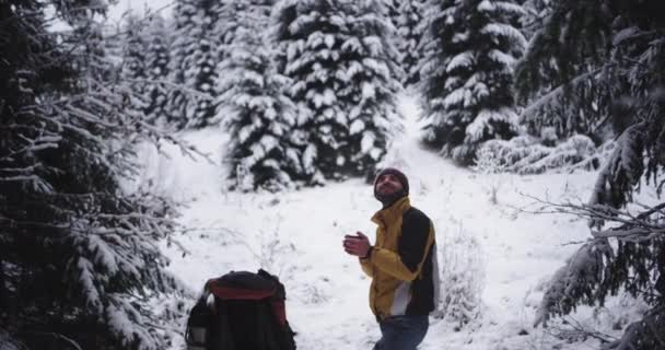 快乐和兴奋的旅游男子在雪林中满是雪,他停下来欣赏所有的美丽,并得到更多的热饮一些热茶从铁杯 — 图库视频影像