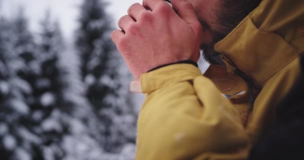 Karismatisk turist porträtt av frysta röda händer i en hård vinter mitt i skogen dricker han lite hett te för att bli mer varm och fortsätta sin resa. skott på Red Epic — Stockvideo