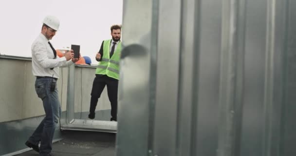 Buen equipo en el sitio de construcción pasar un rato divertido juntos en la azotea de la construcción de baile y disfrutar del tiempo juntos después de que terminaron el trabajo multiétnico grupo de trabajadores — Vídeos de Stock