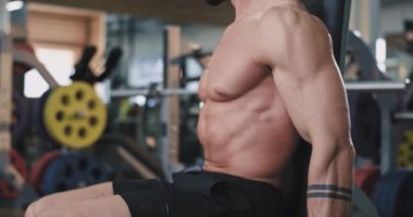 Spor salonunda spor yapan bir spor giyimde iyi görünümlü fit adam bir halter kaldırma konsantre