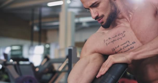 Porträtt av en perfekt Looking Fit Guy koncentrerade arbetar på hans biceps lyfta upp hantel i en stor rymlig gym klass — Stockvideo