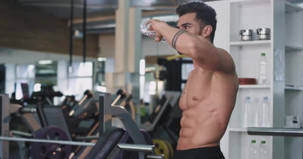 Nach einem harten Fitnesstraining schöner Mann durstig Trinkwasser aus einem Plastikwasser sehr brutal aussehendes Bodybuilding-Konzept — Stockvideo
