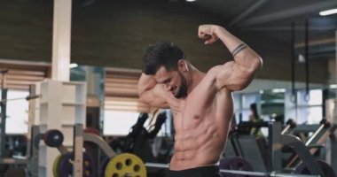 Vücudunun tüm kas gösteren spor salonunda gülümseyen büyük çekici atletik adam vücut geliştirme konsepti