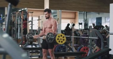 Yakışıklı vücut geliştirme adam beden dersinde çok çalışan vücudunun kas geliştirmek için zor egzersizleri