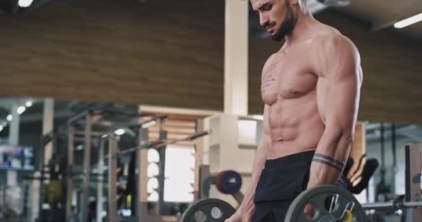 Handsome guy athletic man have workout day on his gym class lifting up the weights to development the biceps muscles — Stock Video