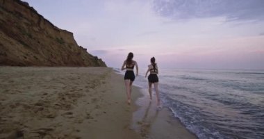 İnanılmaz manzara video deniz suyu ile plajda sabah çalışan iki genç bayanlar