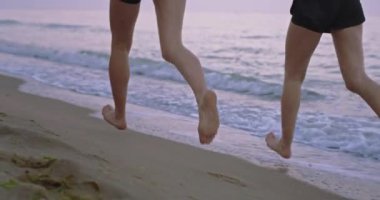 Plaj tarafında sabah iki bayan birlikte çalışan sabah su ile bacaklar ayrıntıları