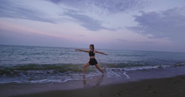 Egészséges életmód koncepció a természet hölgy gyakorló jóga a strandon oldalon a vízben húzódó a test reggel — Stock videók