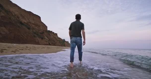 En närbild skott av den snygga unga mans kläder, som han ser ut i fjärran på klipporna — Stockvideo