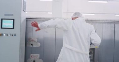Çok karizmatik mühendis adam onun iş yerinde yürürken heyecanlı dans tablet açık ve makine kontrol etmeye başlar