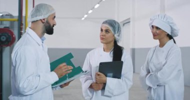 Endüstriyel makine ile ilgili güvenlik notlarını açıklayan büyük üretim mühendisinde mühendis ve fırın işçileri arasındaki toplantı süresi