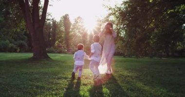 Mutlu anne güzel yeşil çim ile parkın ortasında onu küçük şık erkek ile güzel oynuyor