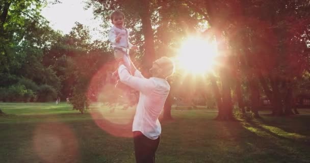 Sorrindo grande menino bonito com seu pai no pôr do sol jogando muito adorável juntos sentindo-se feliz e animado vestindo uma roupa bonita — Vídeo de Stock