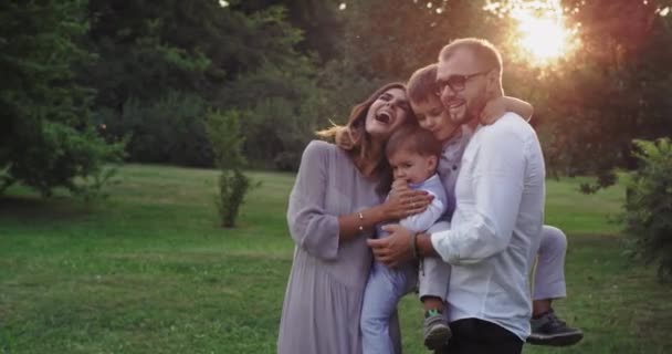 Mutlu ve gülümseyen büyük aile birlikte iki küçük çocuk ve şık giysiler giyen genç ebeveynler harcama an zevk — Stok video