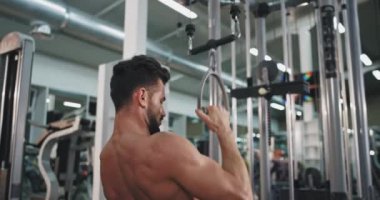 Onun pazı ve triceps için jimnastik ağırlık kaldırma çalışan uygun vücut ile konsantre bir adam Portresi