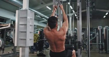 Modern jimnastik sınıfı genç adam onun pazı ve triceps ağırlıkları kaldırma için sert egzersiz yapıyor