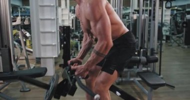 Closeup genç adam spor salonunda bir egzersiz var konsantre ağırlıkları ile egzersizleri iyi yapıyor