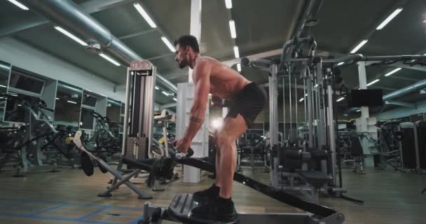 Grande aula de ginástica homem de boa aparência exercícios difíceis de fazer mais músculo levantando os pesos — Vídeo de Stock