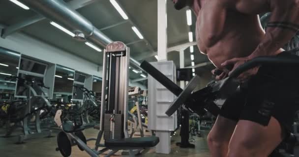 Detailaufnahme eines attraktiven jungen Mannes, der konzentriert und sehr müde in einem Fitnessstudio trainiert — Stockvideo