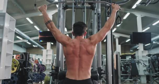 Tomando vídeo de la espalda joven se ejercita duro en su gimnasio concepto de culturismo clase — Vídeos de Stock