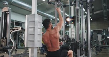 İyi görünümlü adam büyük bir geniş sınıfta onun pazı ve triceps için spor salonunda ağırlıkları kaldırma