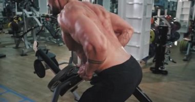 Spor salonu atletik adam daha sert kas yapmak için ağırlık kaldırma yaptığı egzersiz de Ayrıntılar