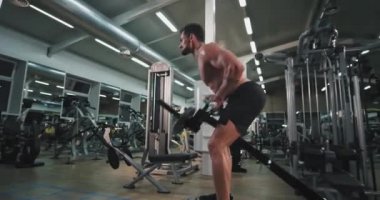 Yorgun ve çekici atletik adam çok konsantre bir spor salonunda iyi çalışıyor