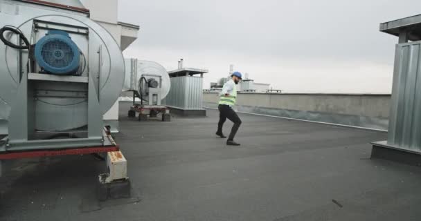 Joven constructor hombre en el sitio de construcción bailando muy emocionado en la parte superior del edificio sintiéndose muy feliz, disfrutando del momento — Vídeo de stock