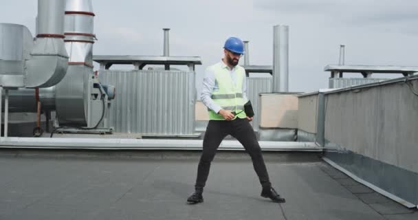 Architecte ou ingénieur heureux et excité parlant à la ration avec quelqu'un tout en tenant une tablette heureux et souriant après la conversation, il a commencé à danser dans — Video