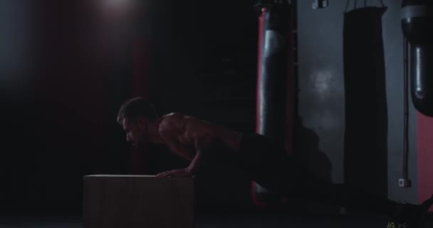 Fuerte y musculoso chico en una clase de fitness haciendo las flexiones sobre la una caja, concentrado trabajando bien tienen un cuerpo dulce — Vídeos de Stock