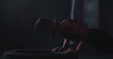 Atletik adam büyük bir lastik lastik üzerinde şınav yapıyor çok sert o çapraz fit sınıfta yoğun bir egzersiz var