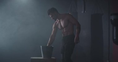 Konsantre vücut geliştirme adam ellerine bazı toz almak ve çapraz fitness sınıfında yoğun bir egzersiz günü başlatmak için hazır olsun